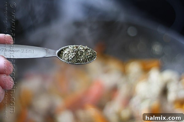 The herbs are sprinkled over the chicken and vegetables in the skillet and tossed to coat.