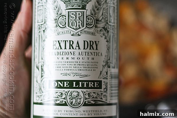 Dry Vermouth being added to the skillet with chicken and vegetables.