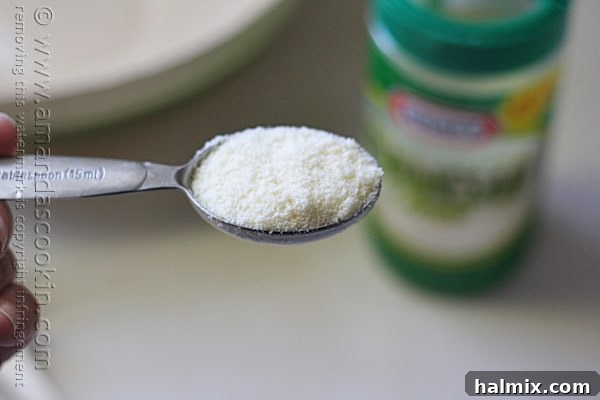 A close-up photo of a tablespoon of Kraft Parmesan cheese, prepared for the pasta.