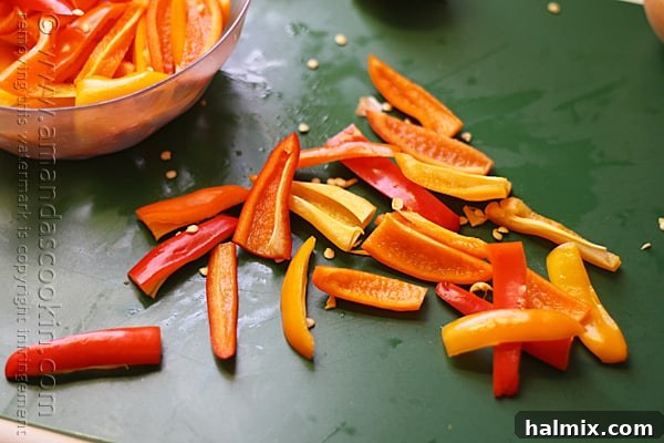 A close-up photo of freshly chopped red and orange sweet peppers, ready for cooking.