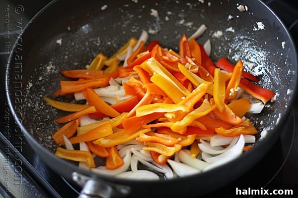 The chicken has been added back to the skillet with the sautéed peppers and onions, ready for the next step.