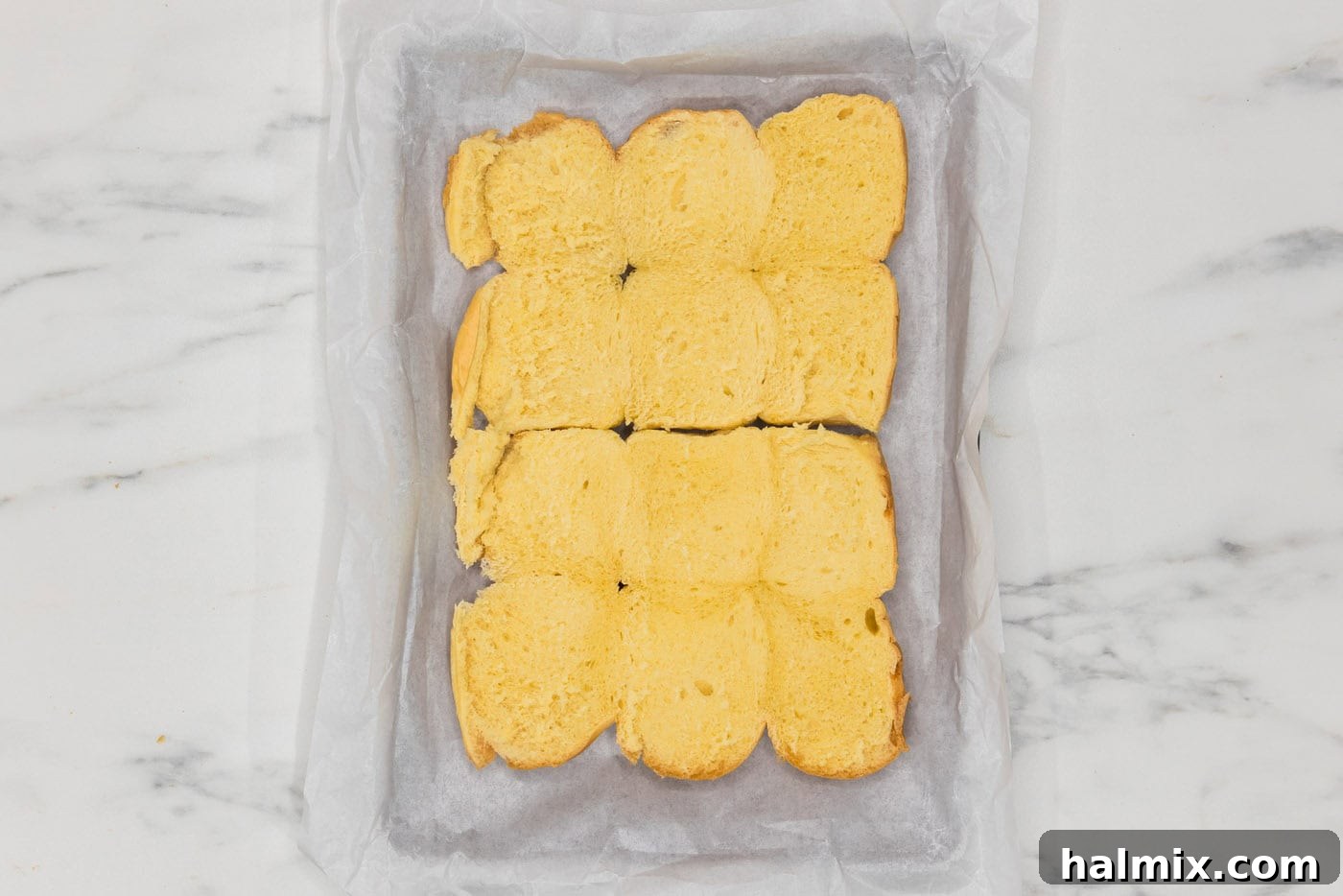 slider buns in a parchment lined baking dish