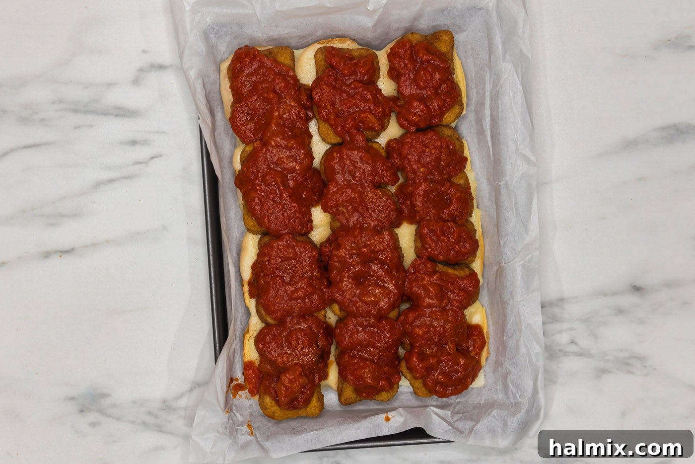 marinara sauce added on top of chicken nuggets and cheese