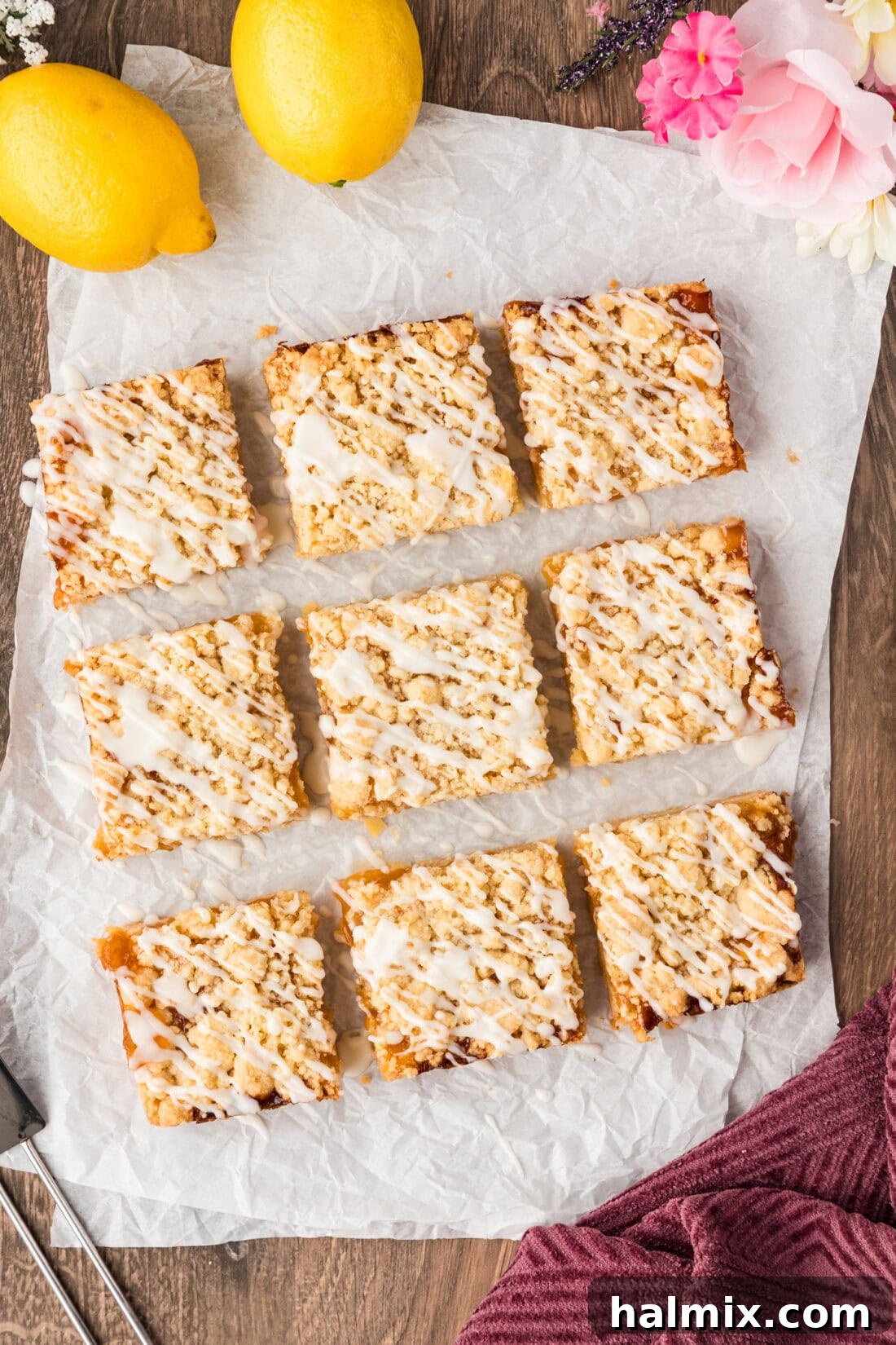 Lemon Streusel Squares cut into 9 squares resting on parchment paper, ready to be picked up