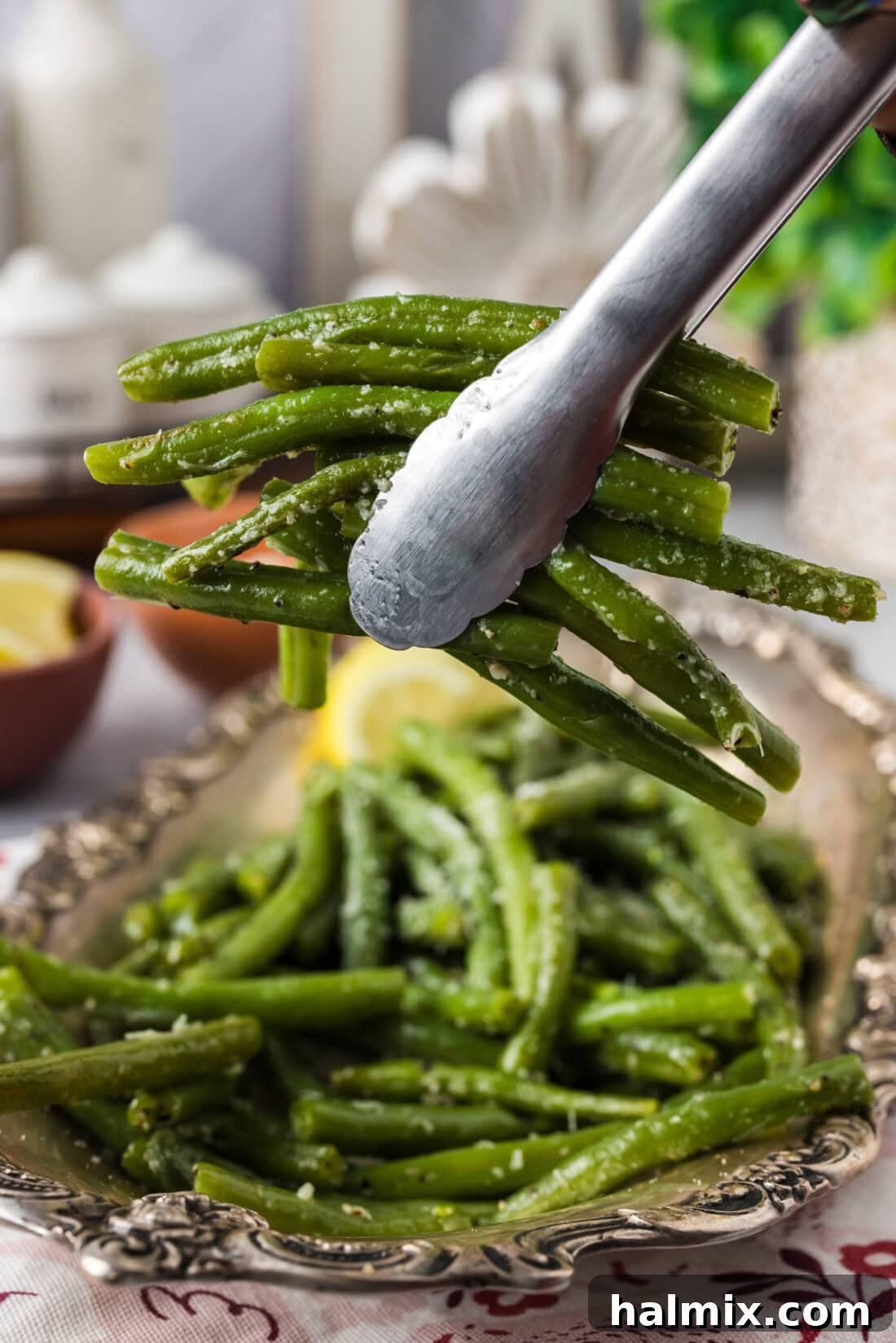 Quick and Perfect Instant Pot Green Beans 2 Tongs holding up a bunch of freshly cooked Instant Pot Green Beans, perfectly seasoned and ready to serve.