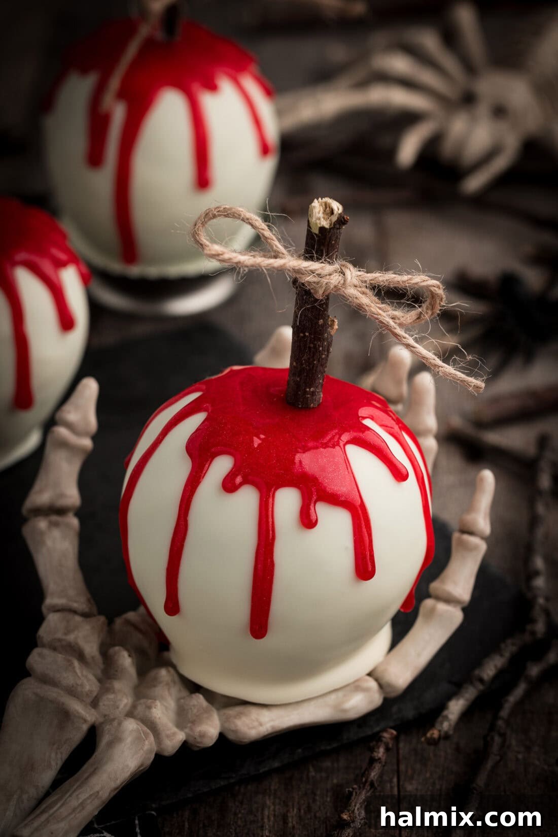 Bloody Candy Apple resting on a skeleton hand, a creepy Halloween display