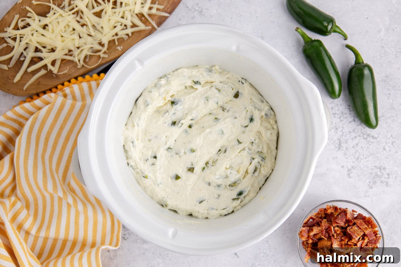 overhead of crockpot jalapeno popper dip in a slow cooker, ready for serving