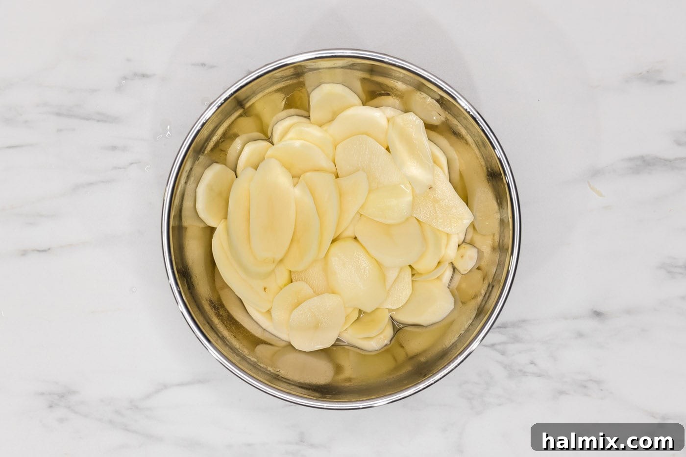 Rich and Creamy Slow Cooker Scalloped Potatoes 5 thinly sliced potatoes in a bowl