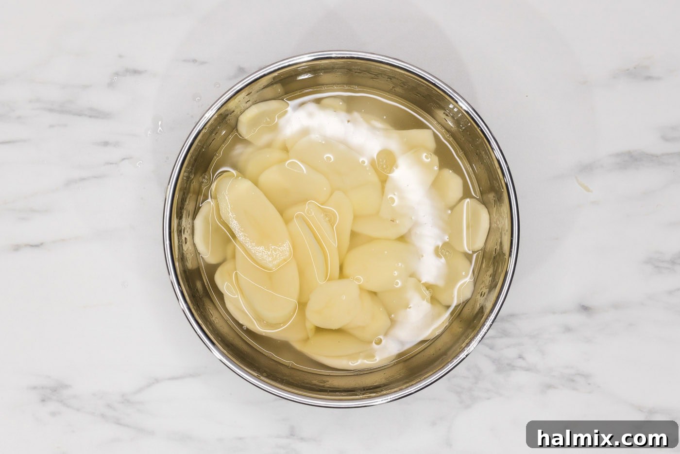 Rich and Creamy Slow Cooker Scalloped Potatoes 6 thinly sliced potatoes in a bowl of water