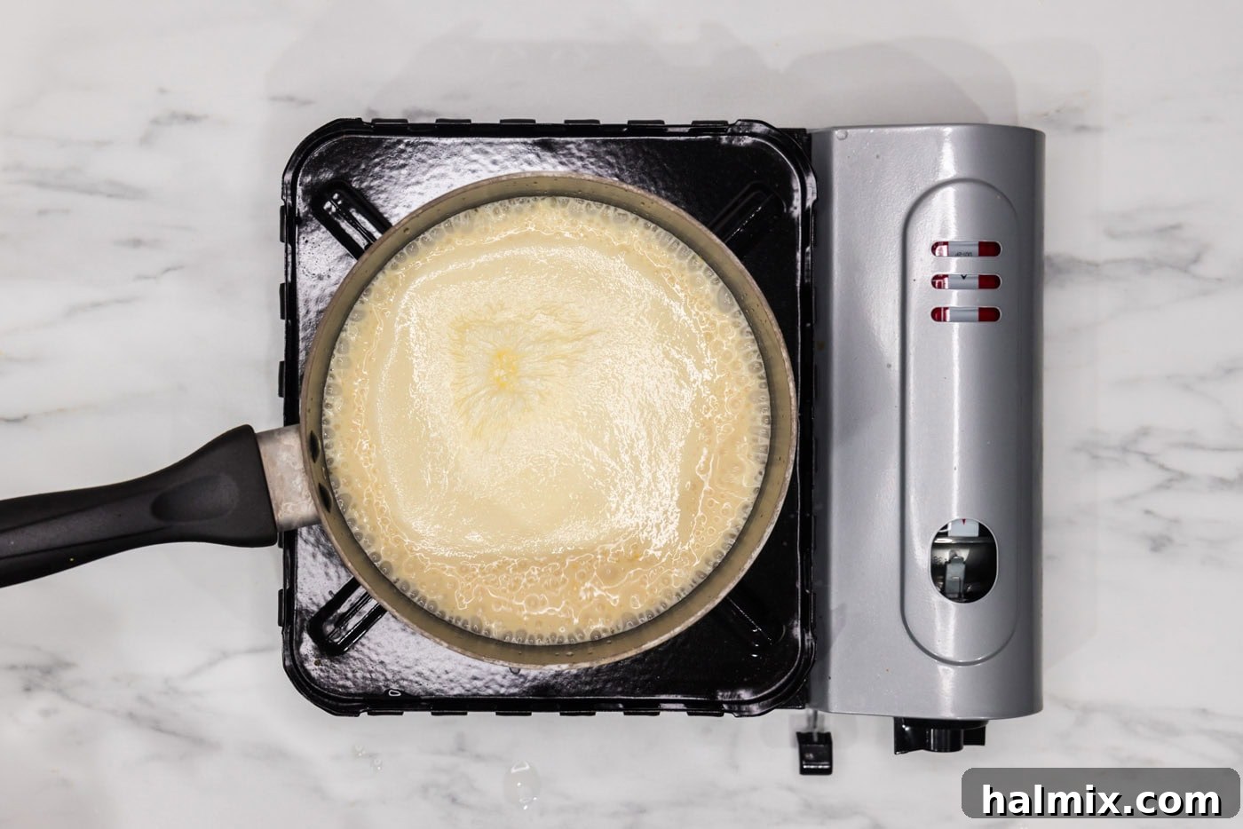 Rich and Creamy Slow Cooker Scalloped Potatoes 9 cheese sauce in a saucepan for scalloped potatoes