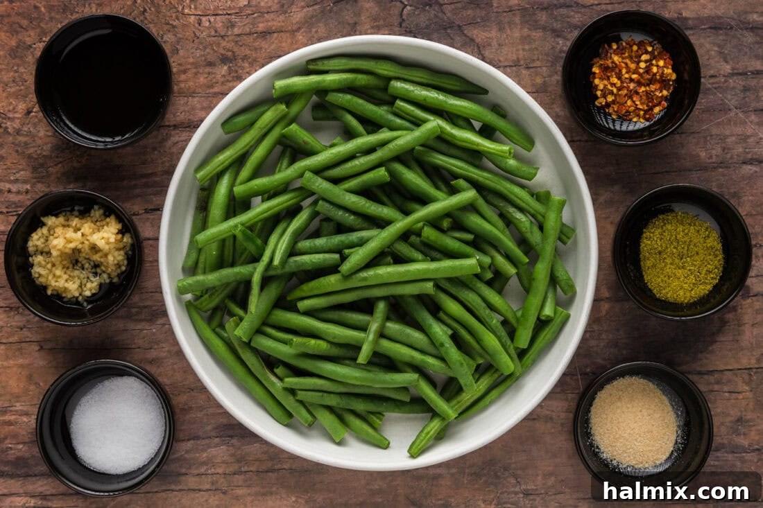 Sautéed Green Beans with Garlic and Lemon Zest 4 A vibrant display of fresh ingredients laid out for Sautéed Green Beans, including green beans, sesame oil, garlic, and various seasonings.