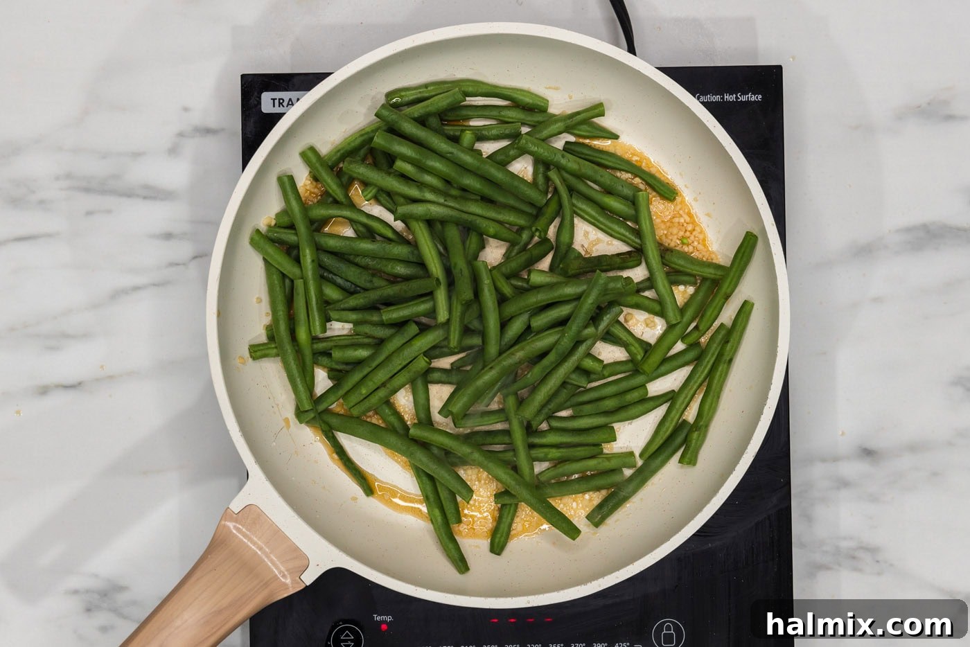Sautéed Green Beans with Garlic and Lemon Zest 5 Fresh green beans simmering in a skillet with garlic and sesame oil, soaking up the delicious flavors.