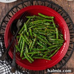Close up photo of Sautéed Green Beans on a red plate, highlighting their appetizing texture and vibrant color.