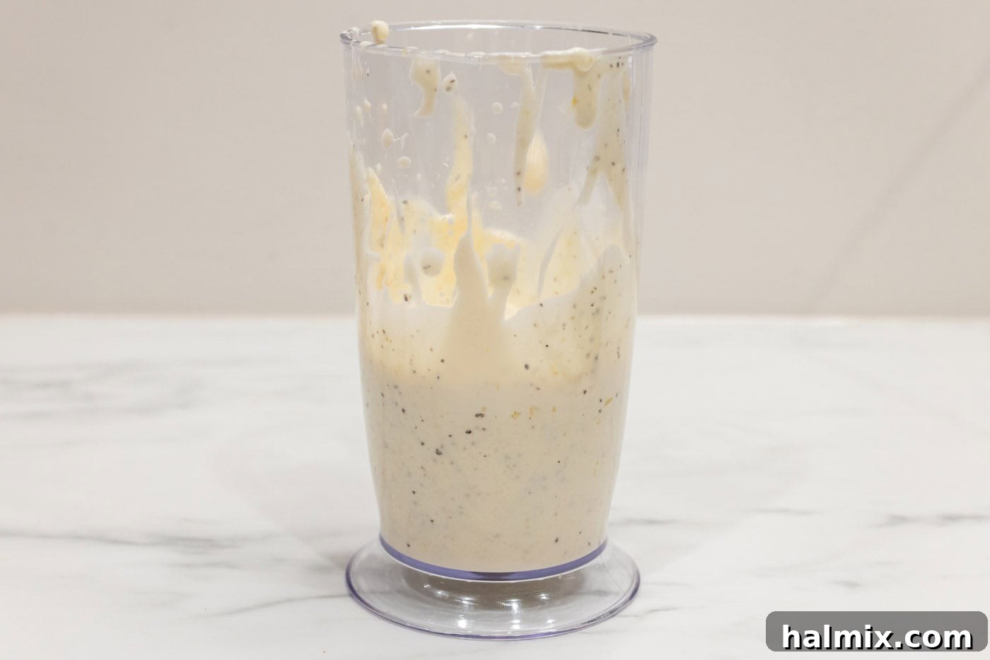 The immersion blender has finished its work, resulting in a beautifully smooth and creamy Garlic Aioli inside the blending cup, ready to be enjoyed.