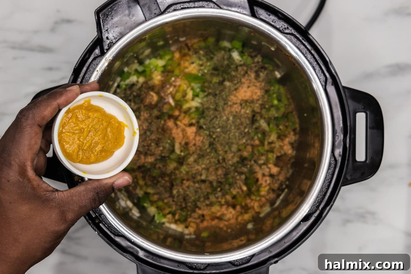 adding seasoning to chopped veggies in an instant pot