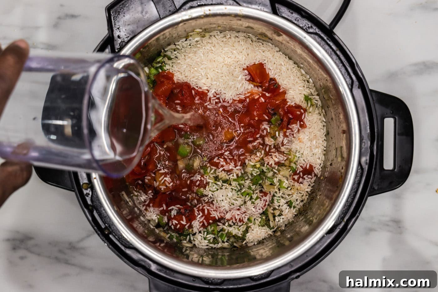 Effortless Instant Pot Jambalaya 10 pouring water into instant pot with jambalaya ingredients