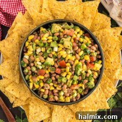 A bowl of vibrant Cowboy Caviar surrounded by crispy tortilla chips, ready for serving.