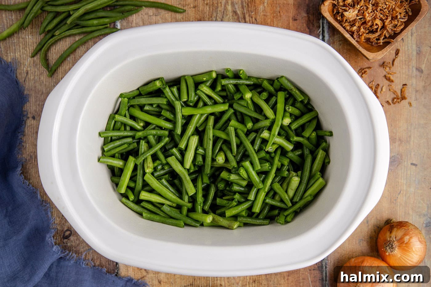 trimmed green beans in a slow cooker crock, ready for other ingredients