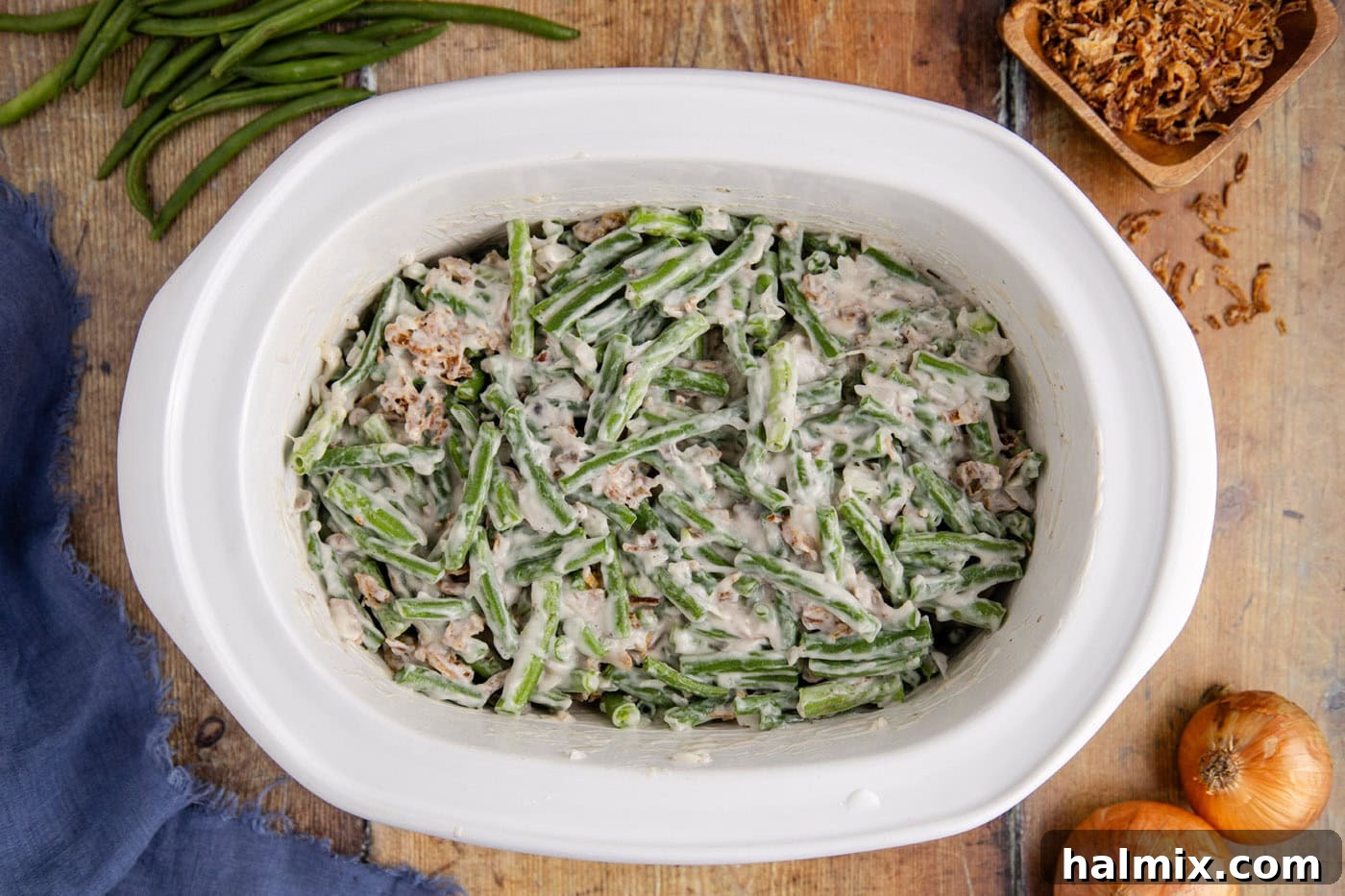 green bean casserole mixture evenly spread in a slow cooker crock