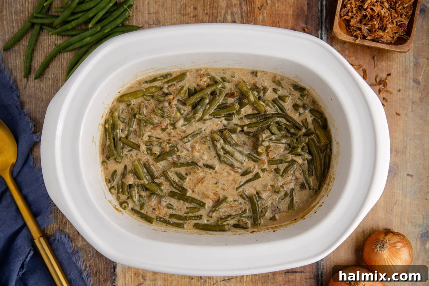 cooked green bean casserole in a crockpot, topped with crispy onions