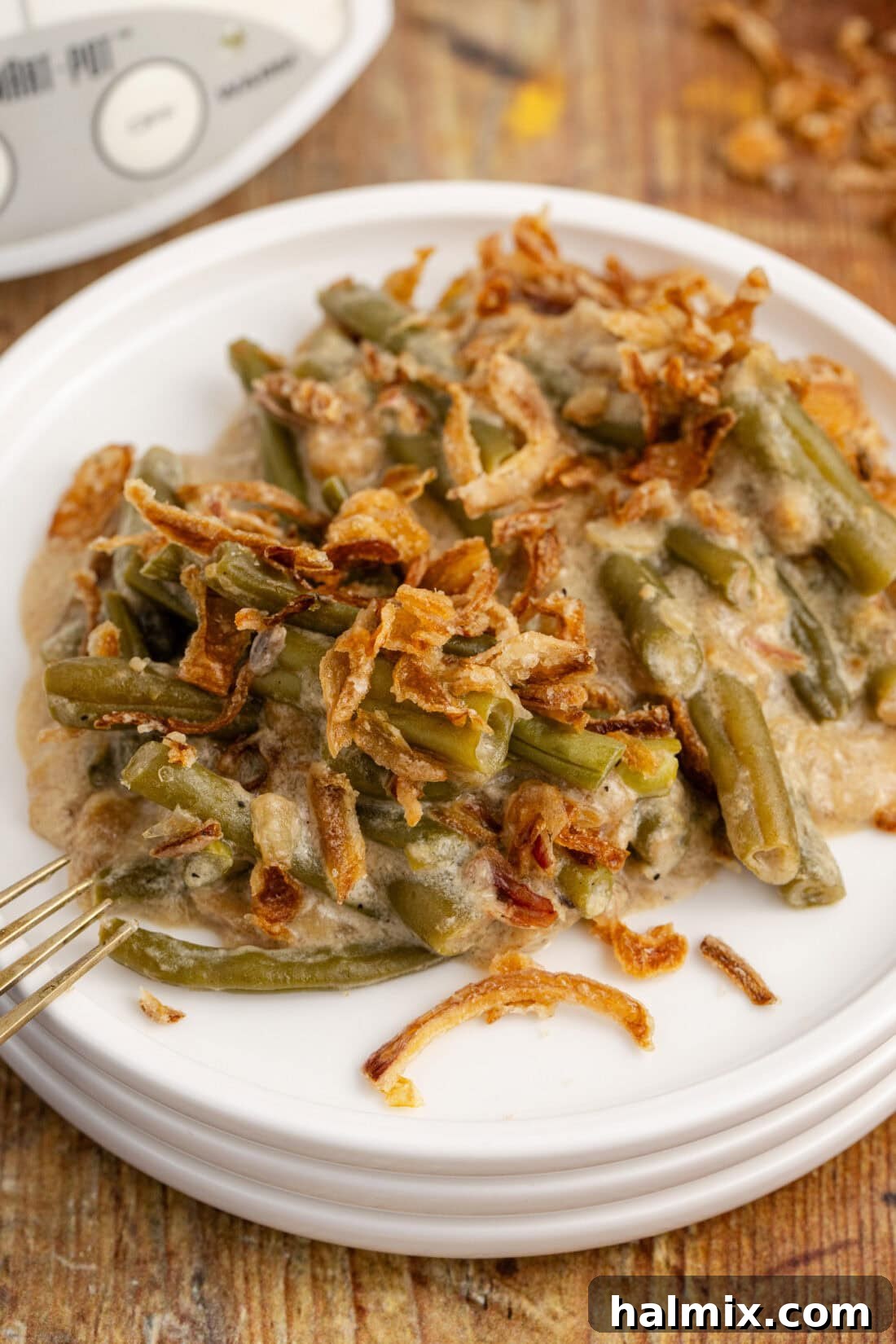 Plate of Crockpot Green Bean Casserole with a side of turkey, ready for a holiday meal.