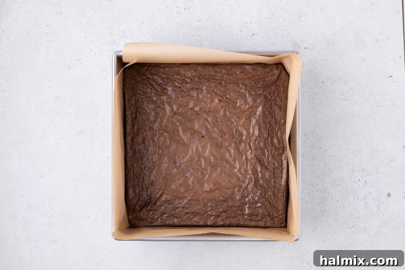 baked brownies in a parchment lined baking pan