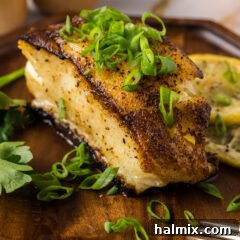 Close up photo of Pan Seared Chilean Sea Bass on a plate, garnished with fresh herbs.