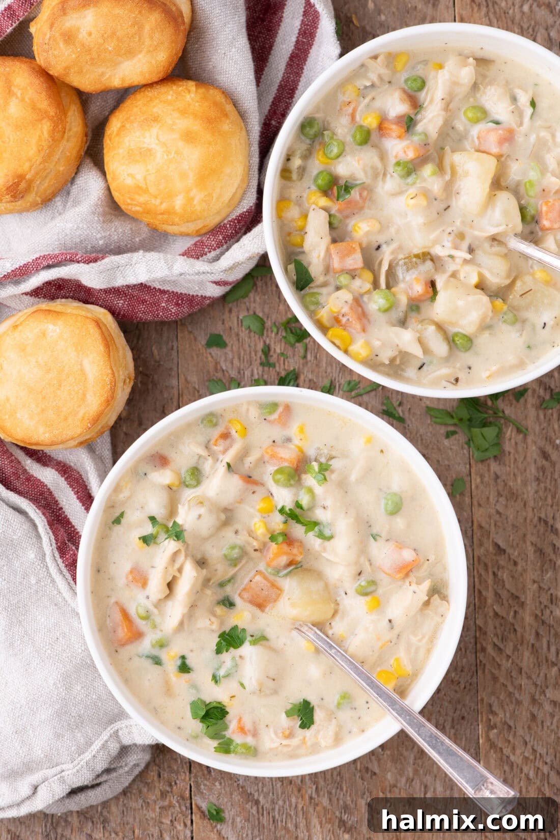 Two bowls of Hearty Chicken Pot Pie Soup served with golden biscuits on the side, ready to be enjoyed.
