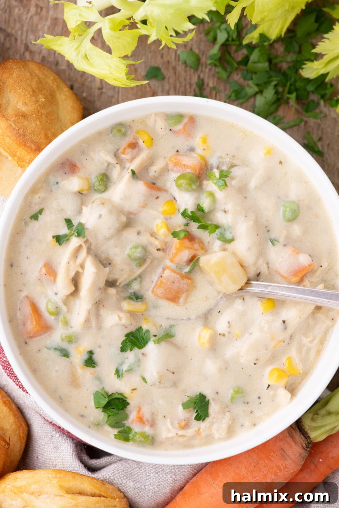 A close-up view of a single bowl of creamy Chicken Pot Pie Soup, showcasing tender chicken pieces and colorful vegetables swimming in a rich broth.