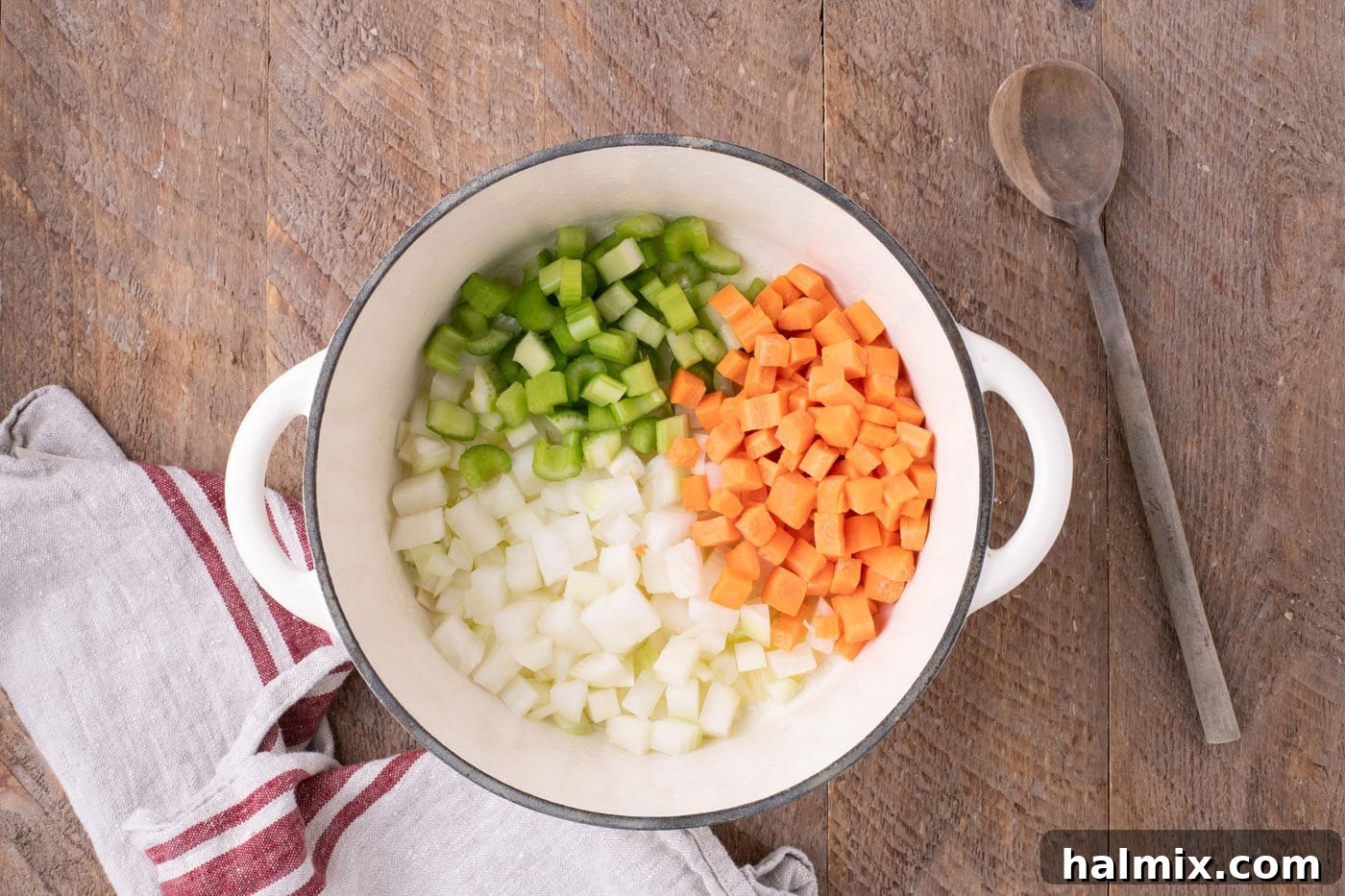 Onions, carrots, and celery gently sautéing in melted butter within a Dutch oven, becoming tender and aromatic.