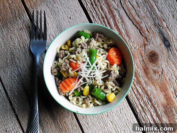 Flavorful Beef Ramen Skillet 2 An overhead photo of a savory ramen noodle and beef skillet served in a blue and white bowl, ready to eat.