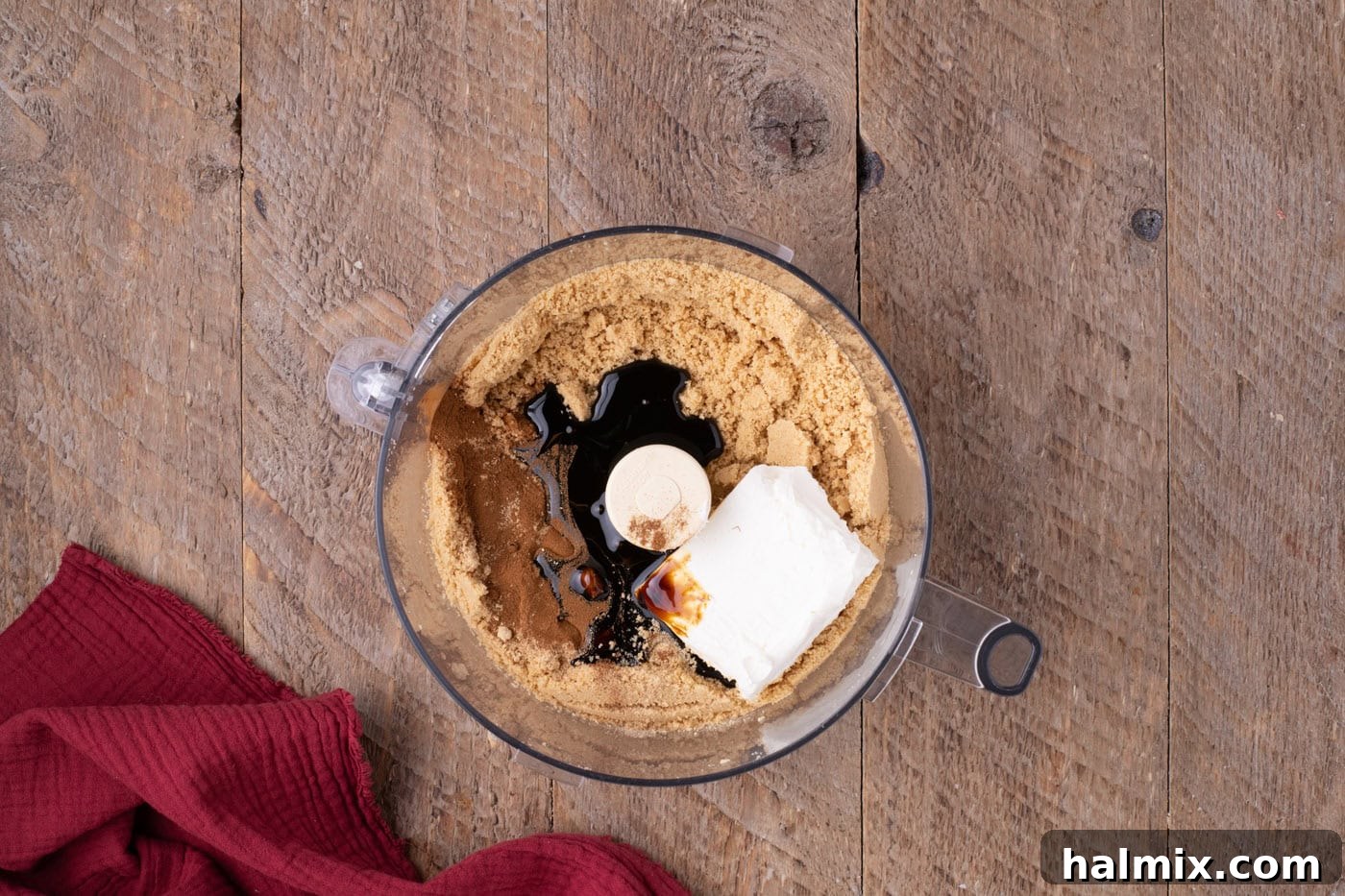 overhead of crushed golden Oreos with cream cheese, spices, and molasses in a food processor