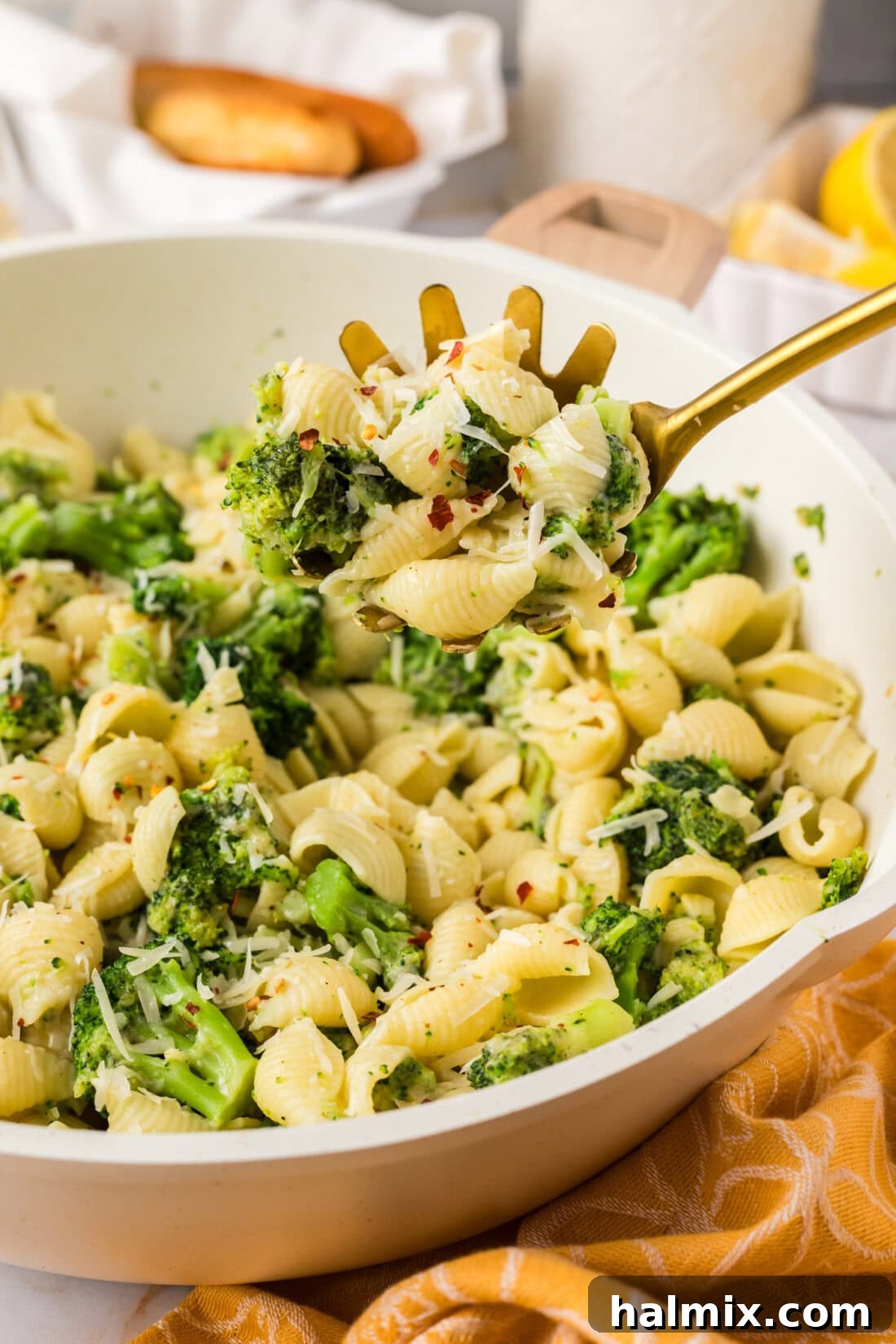 A serving spoon in a skillet, scooping up fresh Broccoli Pasta.
