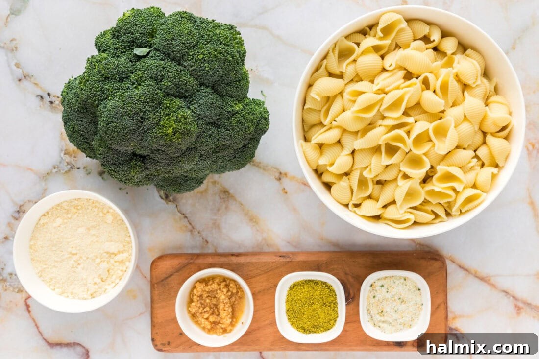 A vibrant selection of fresh ingredients laid out for Broccoli Pasta, including broccoli, pasta, garlic, olive oil, and parmesan cheese.