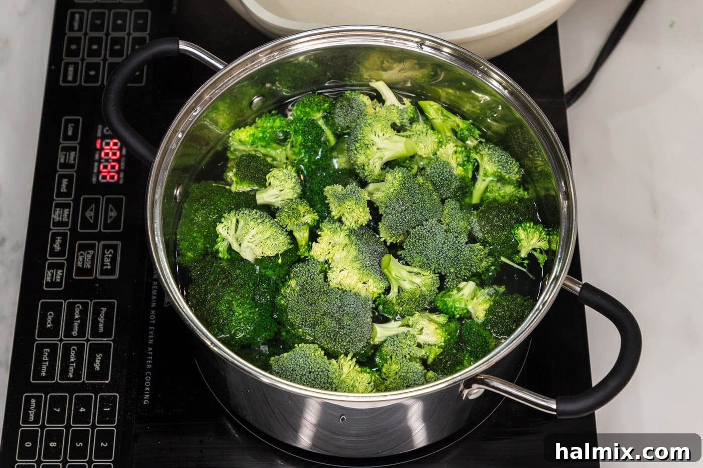 Fresh broccoli florets being blanched in a stock pot of boiling water.