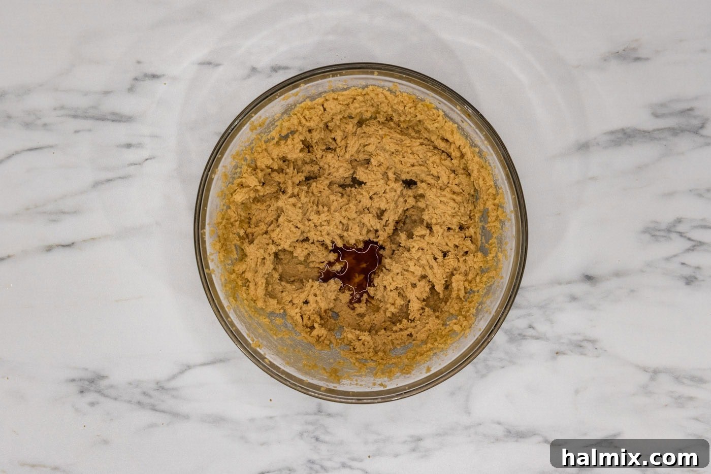 Close-up of creamed butter and sugar mixture in a bowl, showing its light and fluffy texture, ready for the next steps.