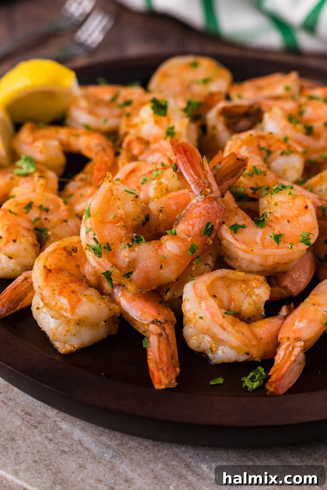 Close up photo of Steamed Shrimp piled on a plate, showcasing its vibrant color and tender texture, garnished lightly.