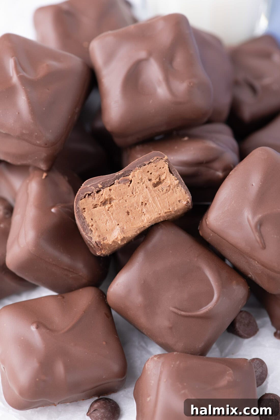 Creamy Cloud Bites 3 Pile of bite-sized Cool Whip Candies, with one cut in half to show the soft, fluffy nougat center.