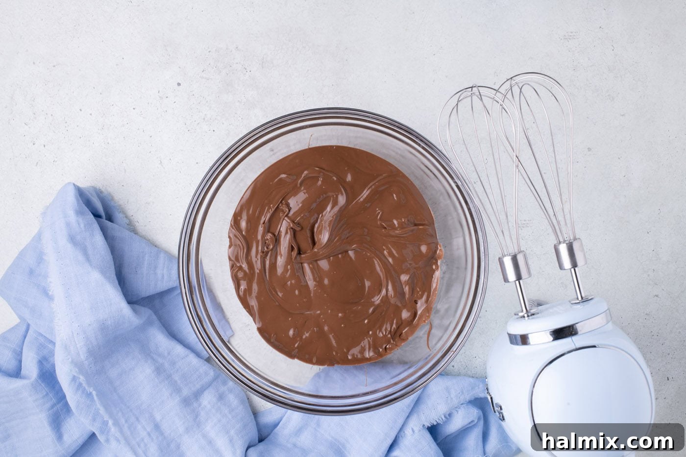 Creamy Cloud Bites 5 Melted milk chocolate in a large microwave-safe bowl, smooth and glossy.