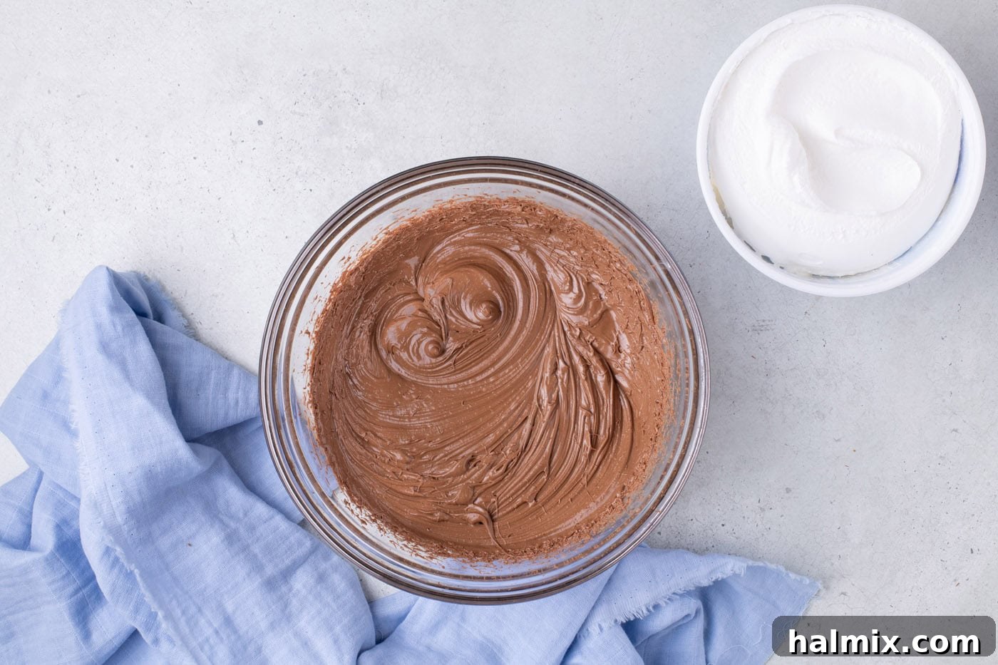 Creamy Cloud Bites 6 Whipped melted chocolate in a bowl, appearing lighter in color and increased in volume.