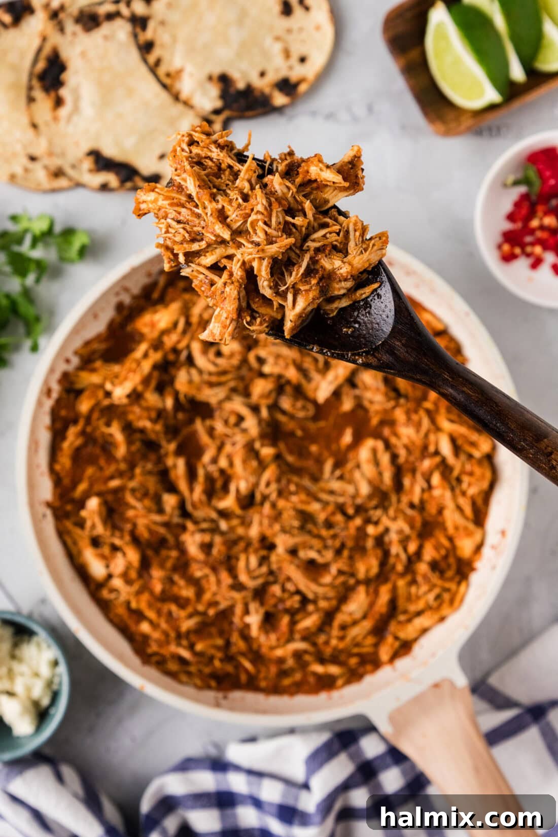 Smoky Chipotle Chicken Tinga 3 Spoonful of Chicken Tinga held above a skillet full of Chicken Tinga