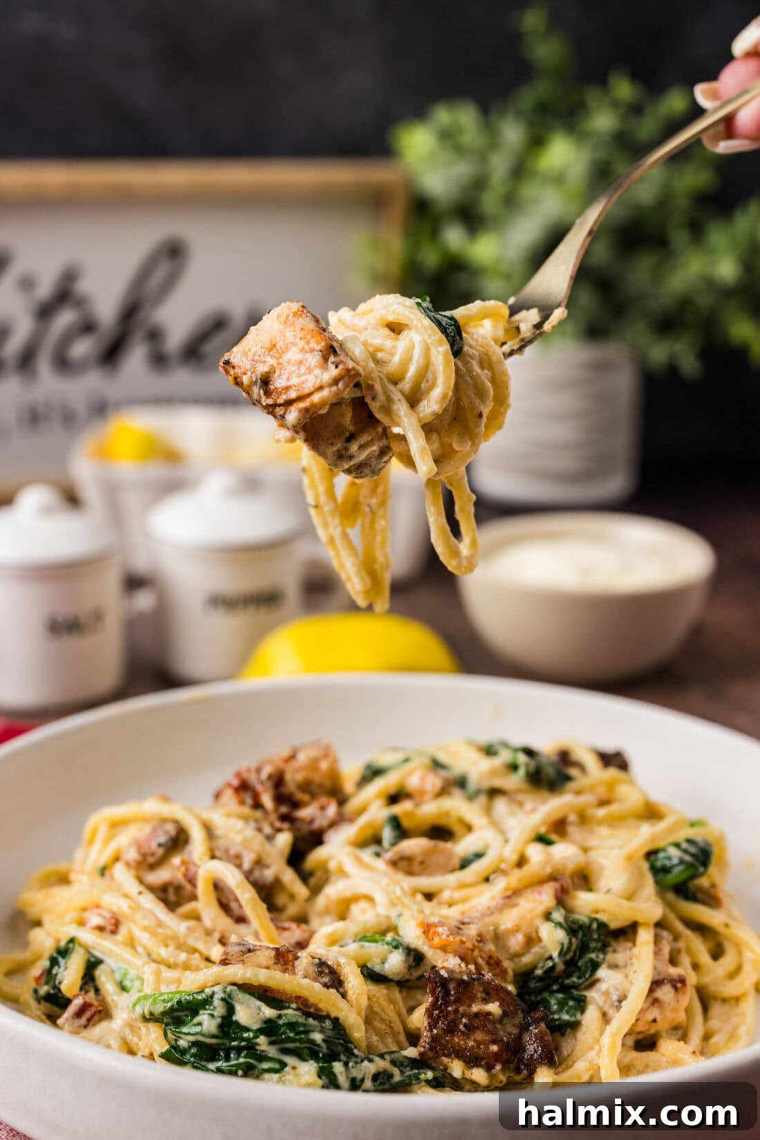 Forkful of Creamy Salmon Pasta held above a plate of Salmon Pasta