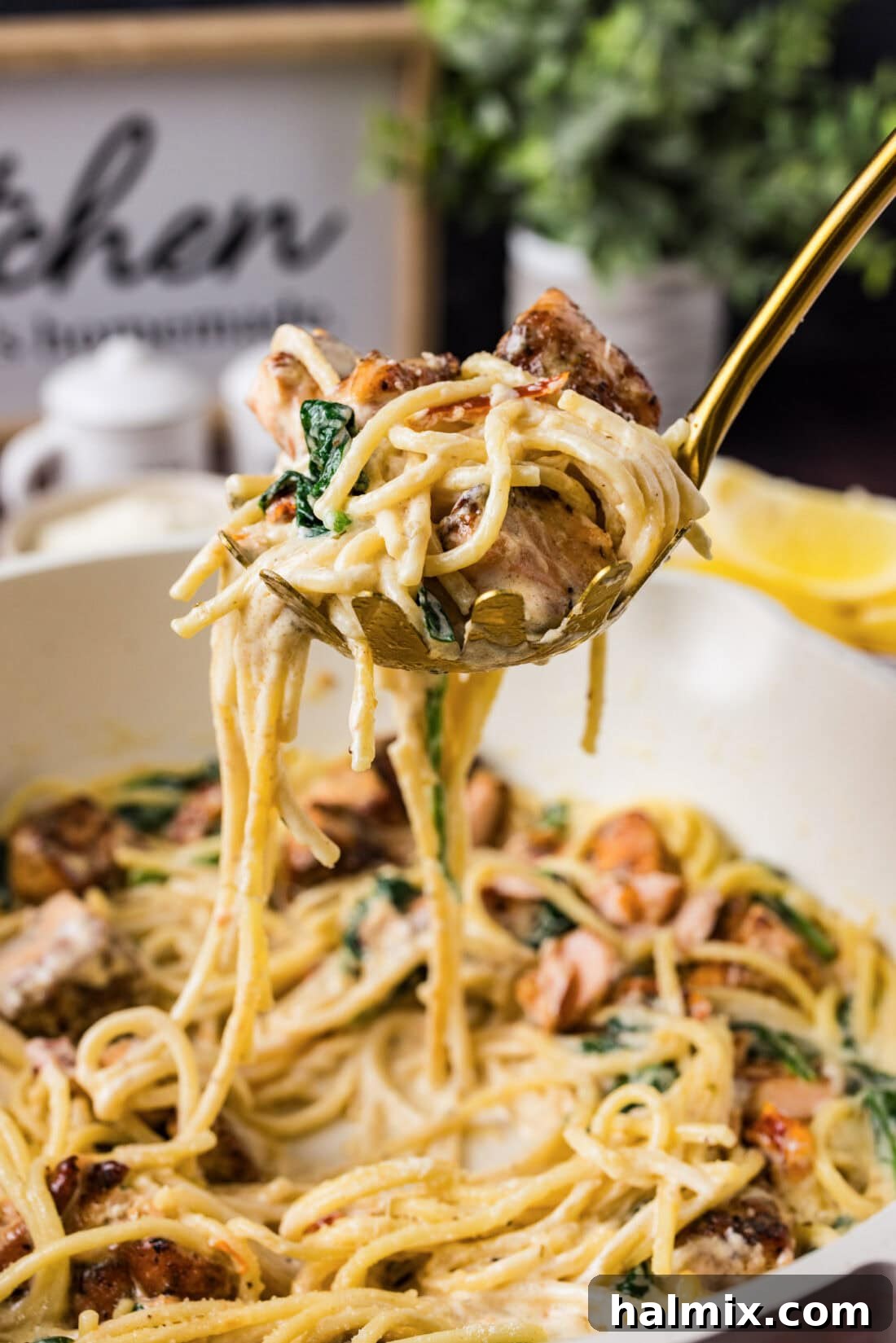 Spoonful of Creamy Salmon Pasta held above a skillet of the finished dish