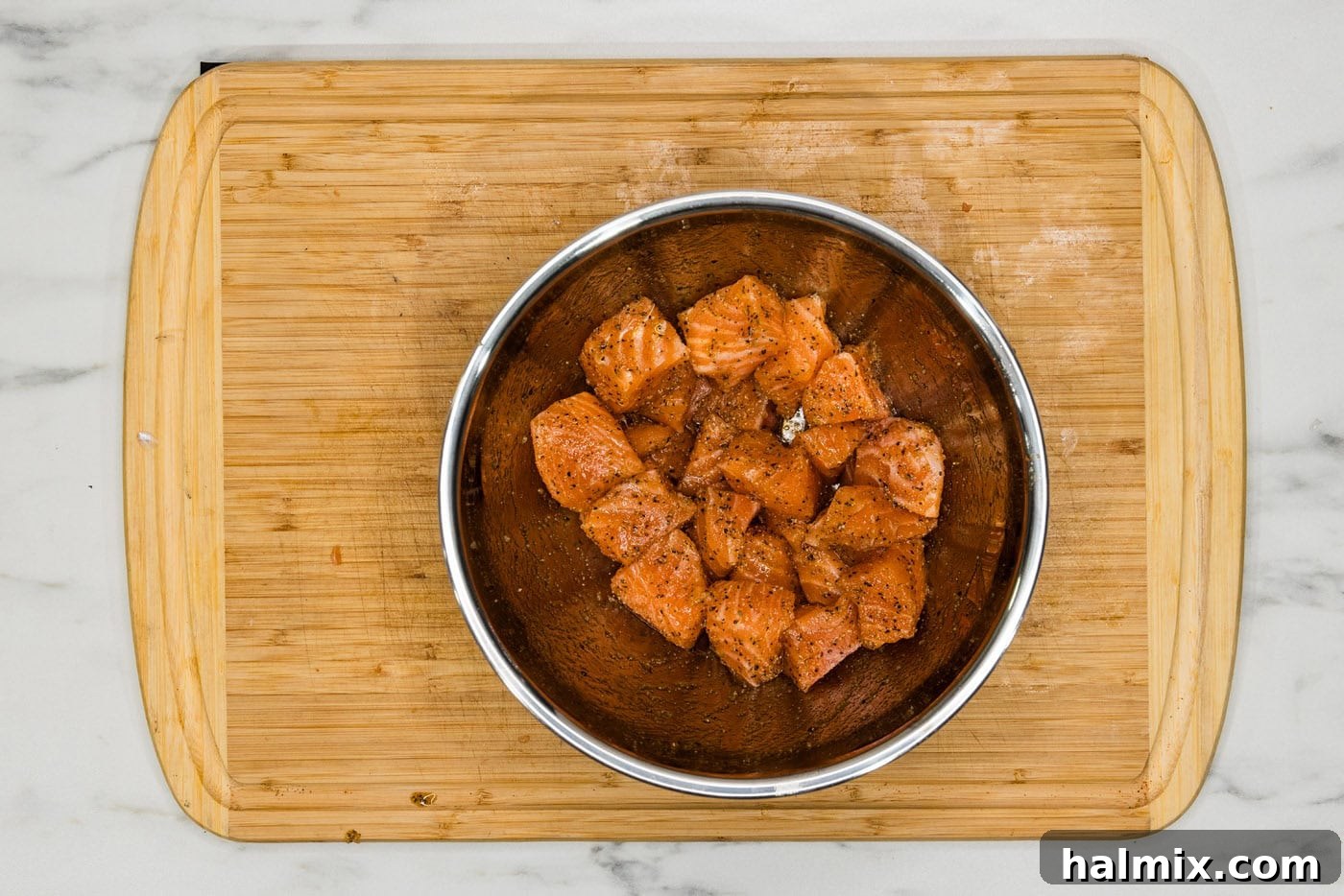 salmon cubes in a bowl with olive oil and seasonings