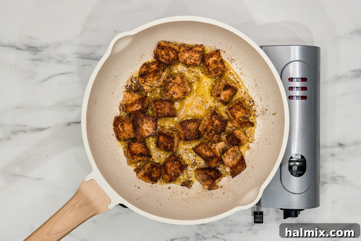 cooked salmon cubes in a skillet