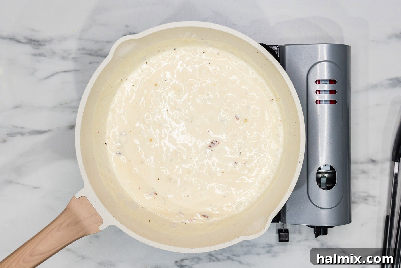 sun dried tomatoes added to cream sauce in a skillet