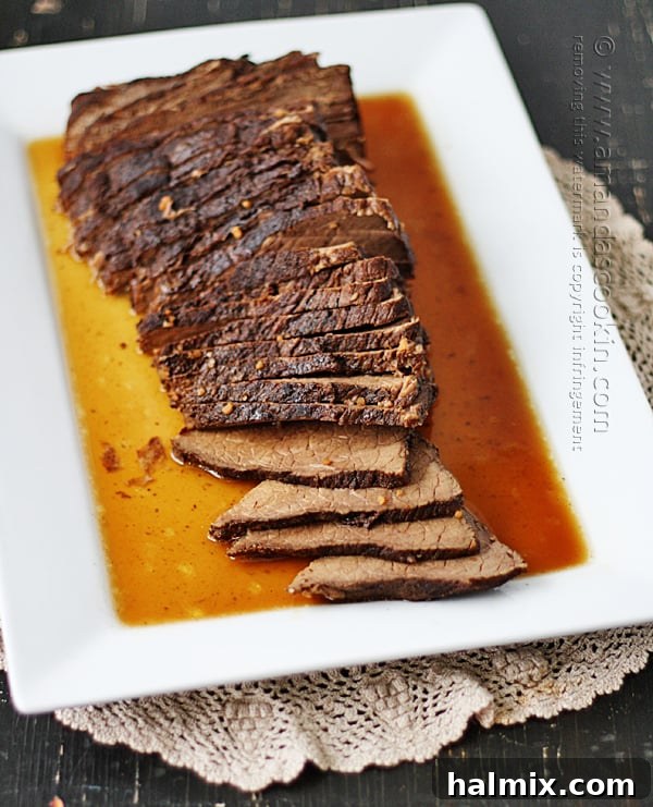 Overhead view of a perfectly sliced slow cooker roast, drenched in a glistening brandy sauce, ready to serve.