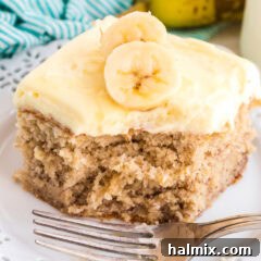 A beautifully presented slice of banana cake, showcasing its moist texture and rich banana flavor.