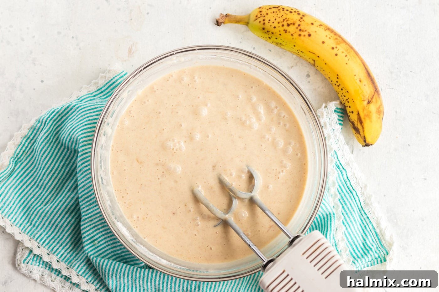 Smooth, light yellow cake batter thoroughly mixed in a large bowl, ready for transfer to the baking pan.