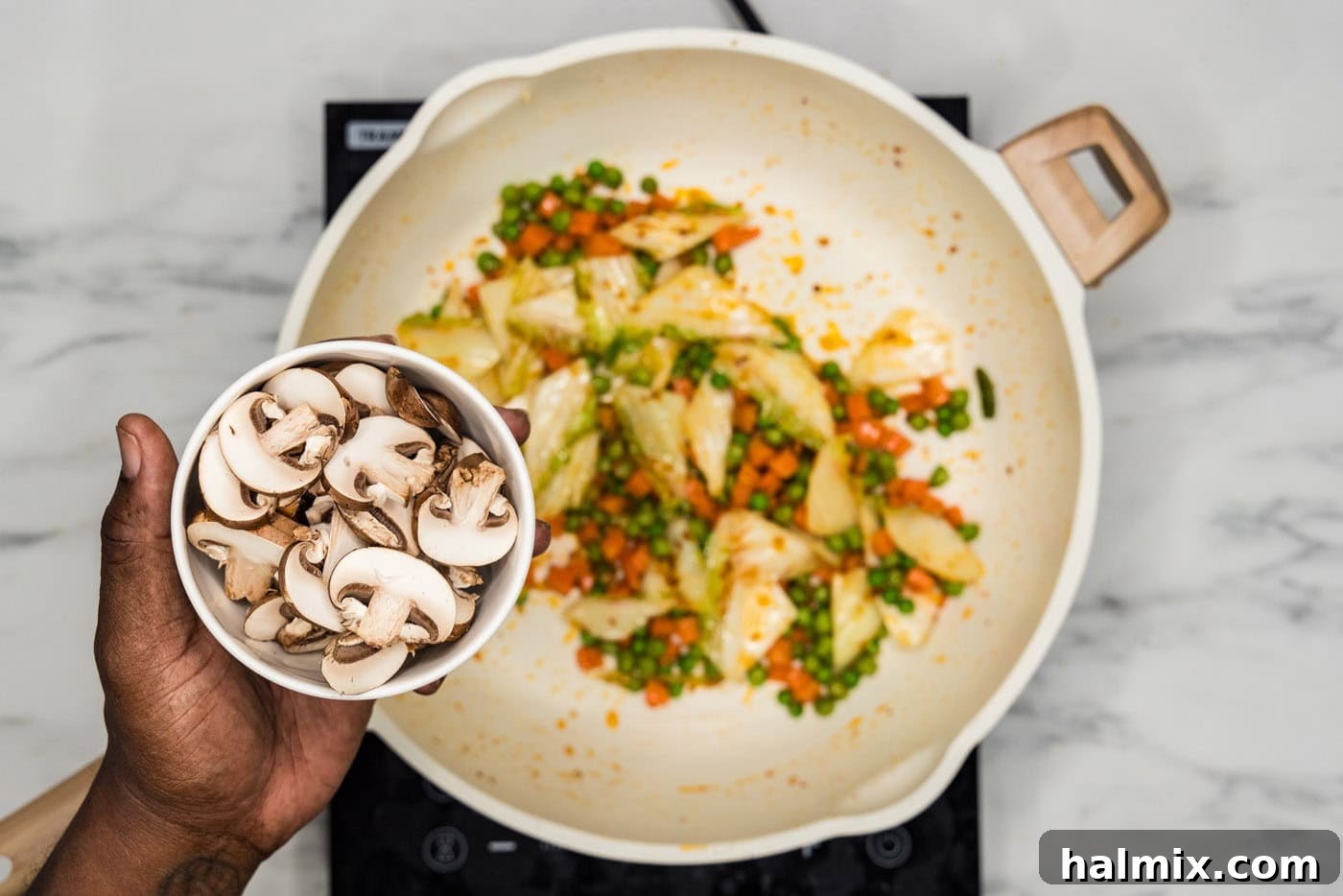 Adding mushrooms to stir-fried garlic, ginger, and cabbage in a skillet